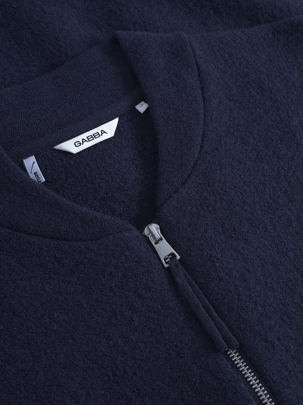 Close-up of Cardiff Led - Navy, a textured zip-up jacket by Gabba, crafted from boiled wool with a silver 2-way zipper and a white GABBA label inside the bomber collar.