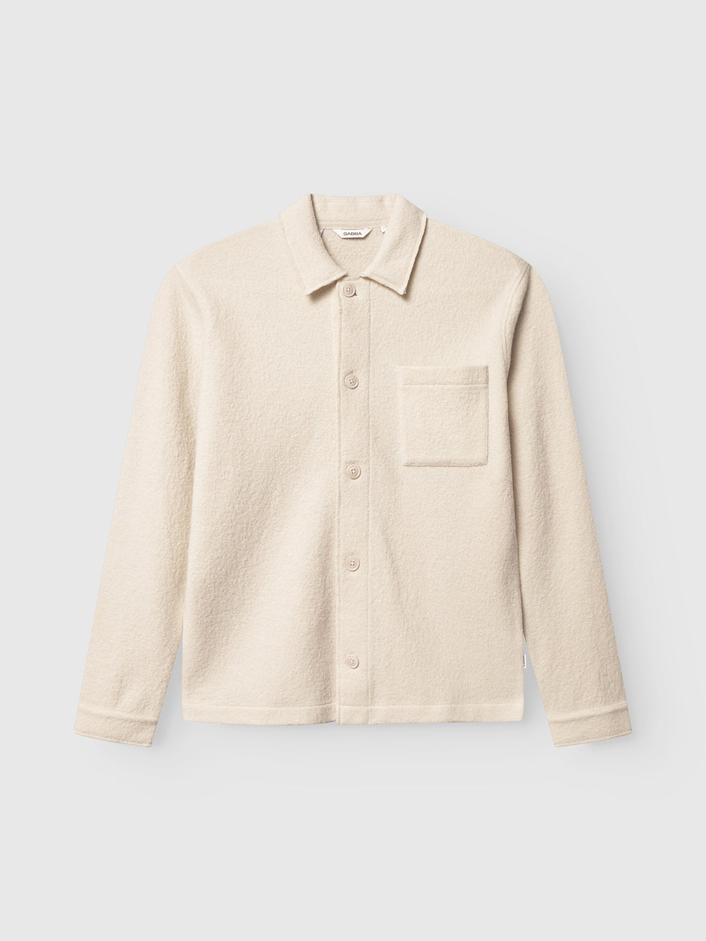 The Gabba Preston Led overshirt in White Almond is a cream-colored, long-sleeve boiled wool shirt with a collar, single chest pocket, and tailored edge, shown on a plain light background.