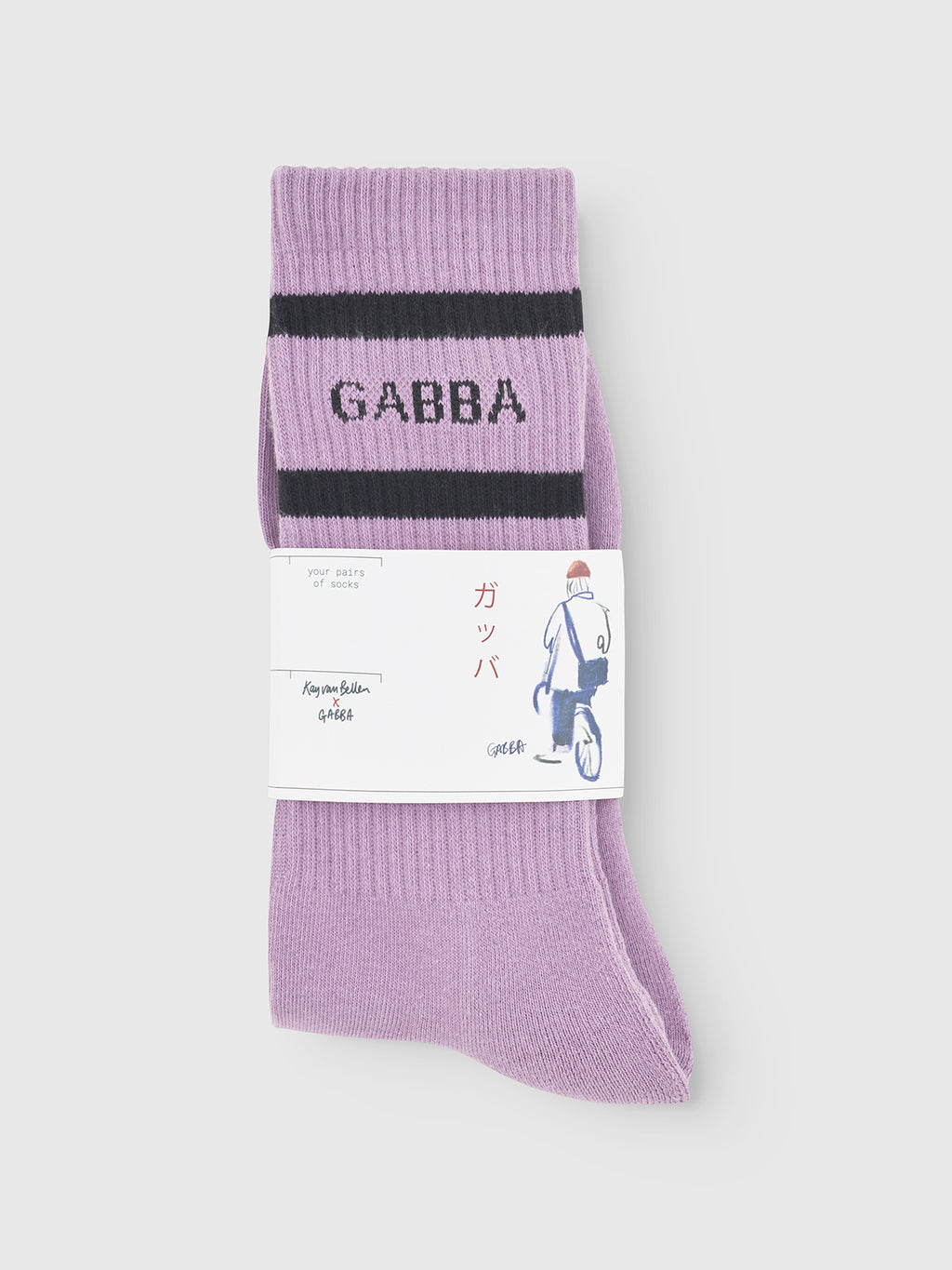 A pair of Zino Socks - Dust Purple by Gabba, featuring black stripes and GABBA woven in black, folded and wrapped in a Japanese-labeled band with a cyclist illustration. Made from breathable cotton for premium comfort.