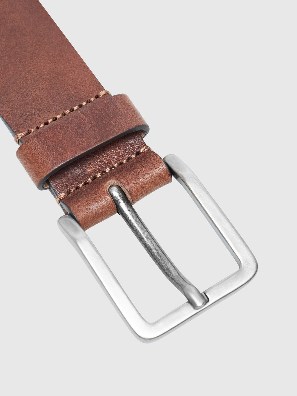 The Gabba Talia Belt in cognac features genuine leather with visible stitching and a sleek silver buckle, set against a light gray background—an elegant, versatile accessory for any wardrobe.