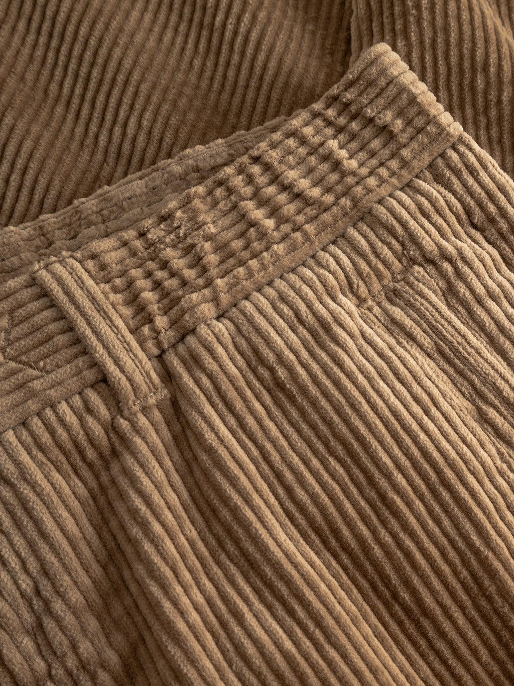 Close-up of Gabba's Monza Ibre - Sand trousers, showcasing the textured, ribbed corduroy fabric, detailed waistband with belt loop, and seam accents—ideal for a sophisticated yet casual look.