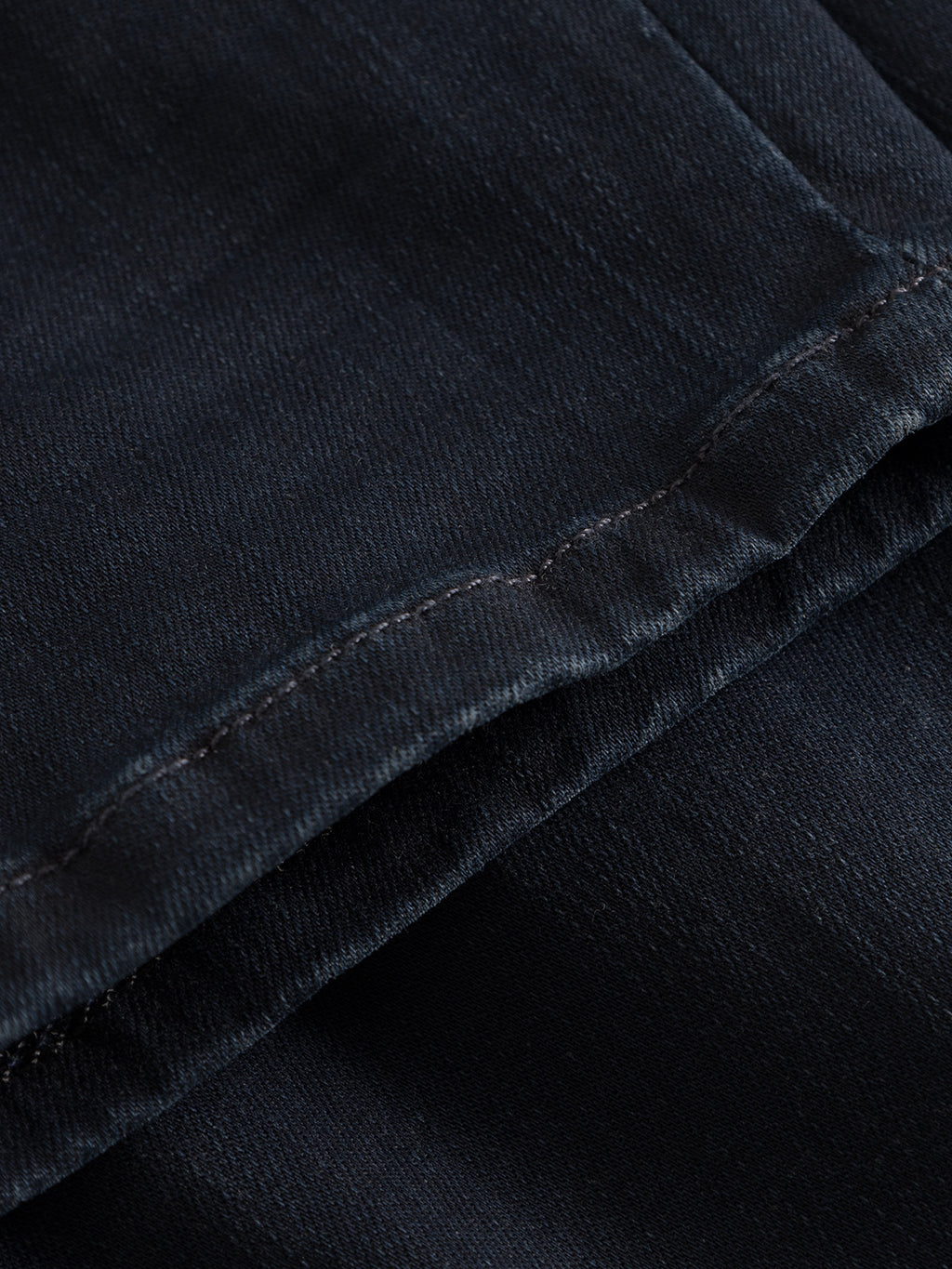 A close-up of the Jones K2291 - Denim Wash by GABBA shows dark denim with visible stitching and reinforced pockets. The subtle diagonal weave underscores its quality and craftsmanship.