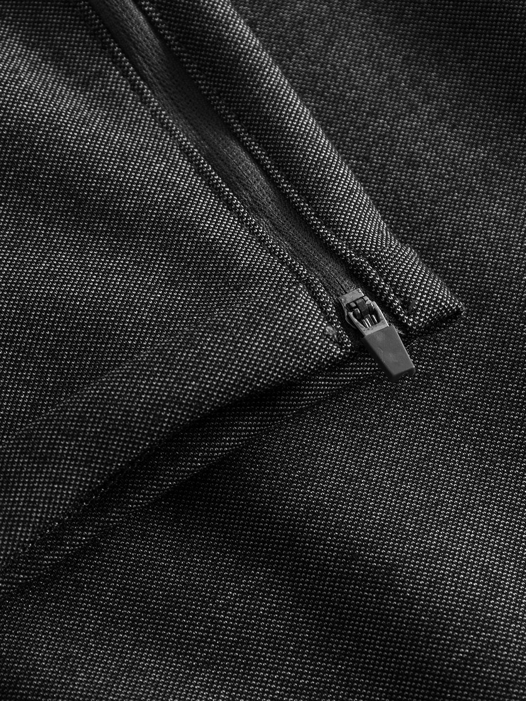 Close-up of Pisa Jersey Pant - Grey Mel by GABBA, showcasing the dark textured, high-stretch fabric and partially open black zipper. The image highlights the detailed weave pattern and sleek design, ideal for achieving a modern metro look.