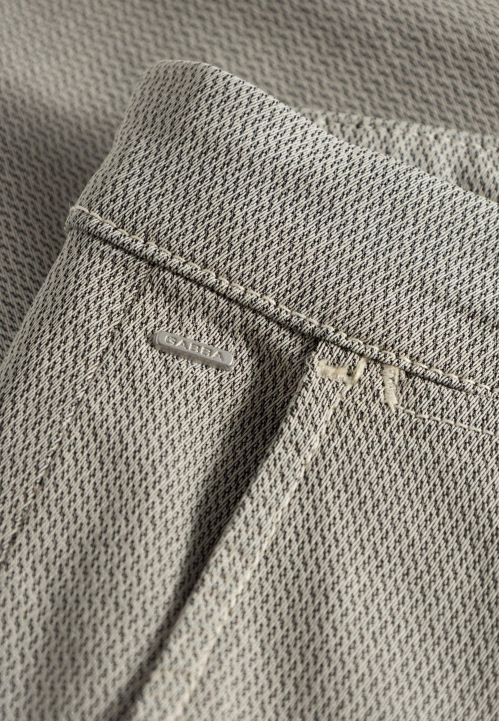Close-up of Gabba Paul K3280 Dale Chino in Birch, highlighting the light gray textured fabric, waistband, belt loop, French pockets, and a partially stitched back pocket with buttonhole detail.