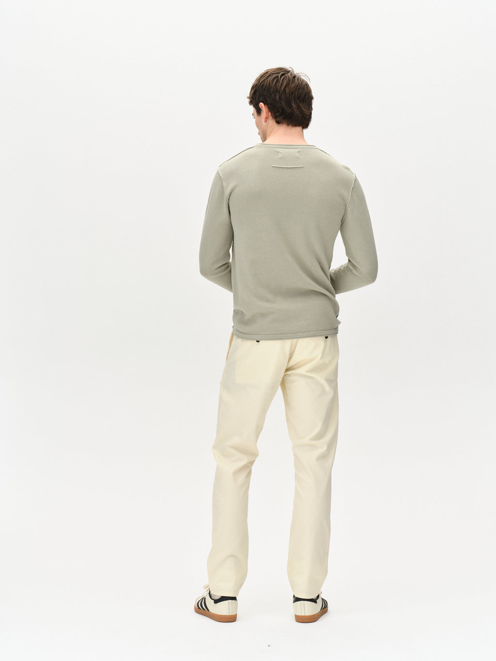 A person with short brown hair stands facing away on a plain white background, wearing a light gray long-sleeve shirt and Gabbas Paul K3280 Dale Chino in Ecru Light, featuring French pockets.