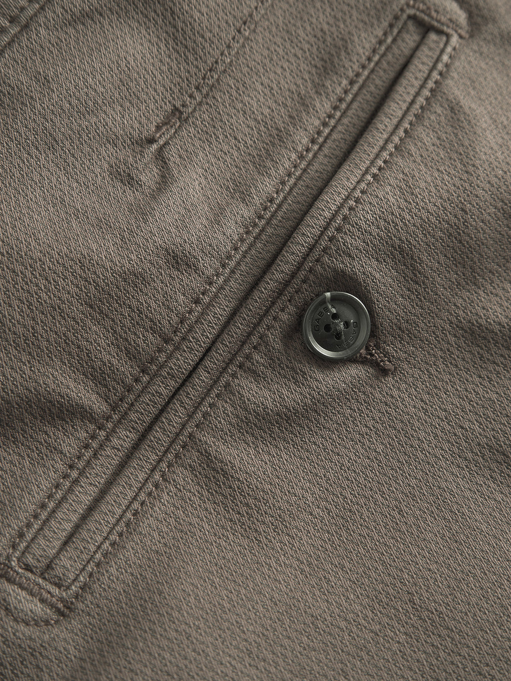 Close-up of the Paul K3280 Dale Chino in dark brown fabric with a textured surface, featuring a horizontal French pocket and a dark gray four-hole button, epitomizing Gabbas meticulous design.