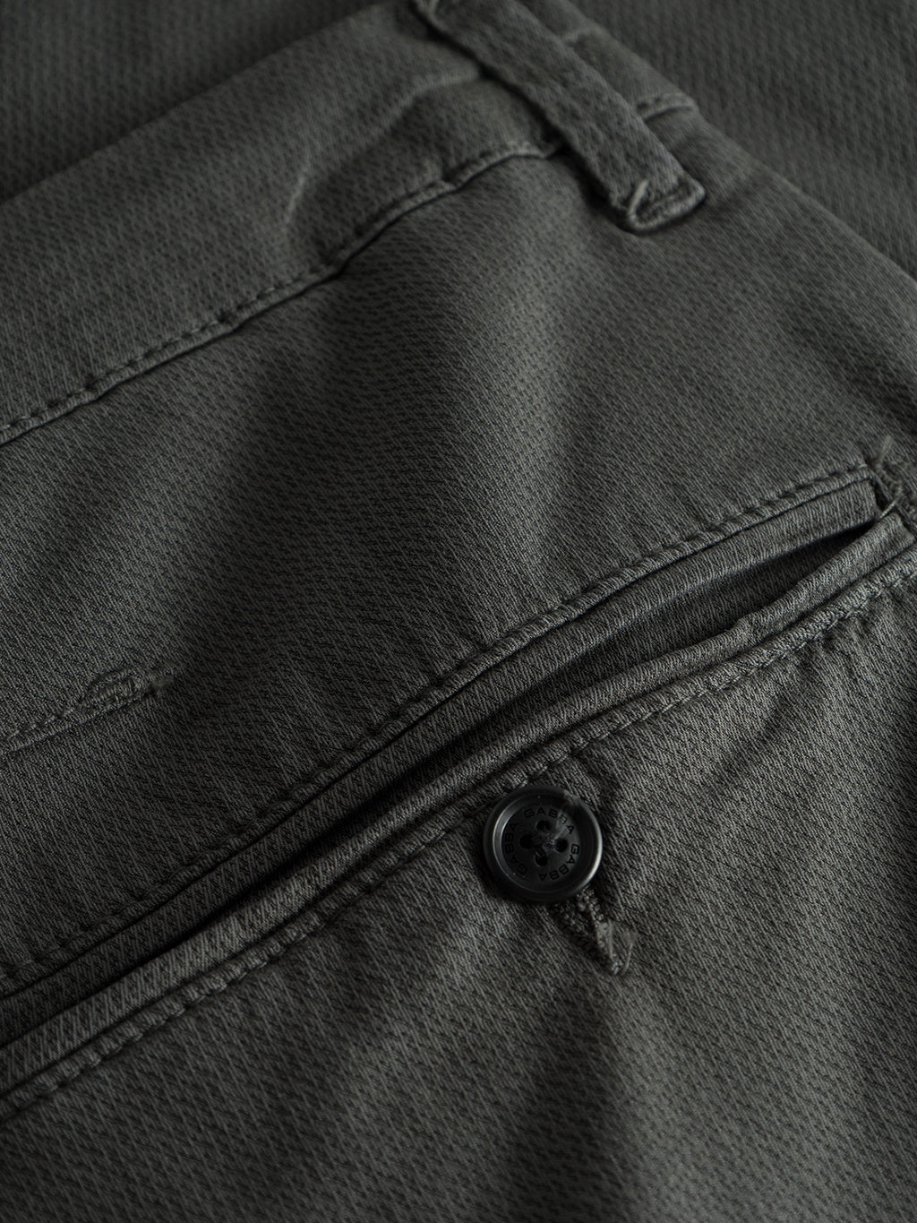 Close-up of the Paul K3280 Dale Chino by GABBA in grey, showcasing a textured fabric pattern, French pockets, and a back pocket with a closed flap and branded black button.