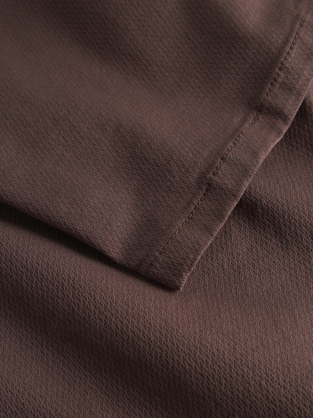 A close-up of the Paul K3280 Dale Chino by Gabba in Burnt Purple shows its soft, textured fabric with visible stitching and overlapping layers, reminiscent of a finely crafted chino pant and creating a subtle pattern across the surface.