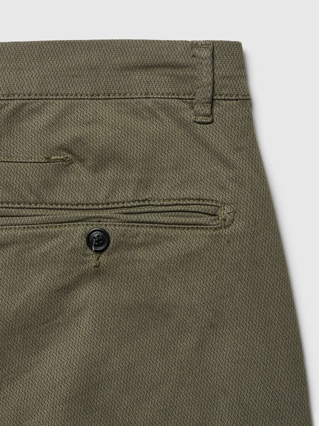 Close-up of the back pocket of Gabbas Paul K3280 Dale Chino in Deep Lichen Green. The textured fabric features a French pocket with a single black button closure and classic waistband belt loop.