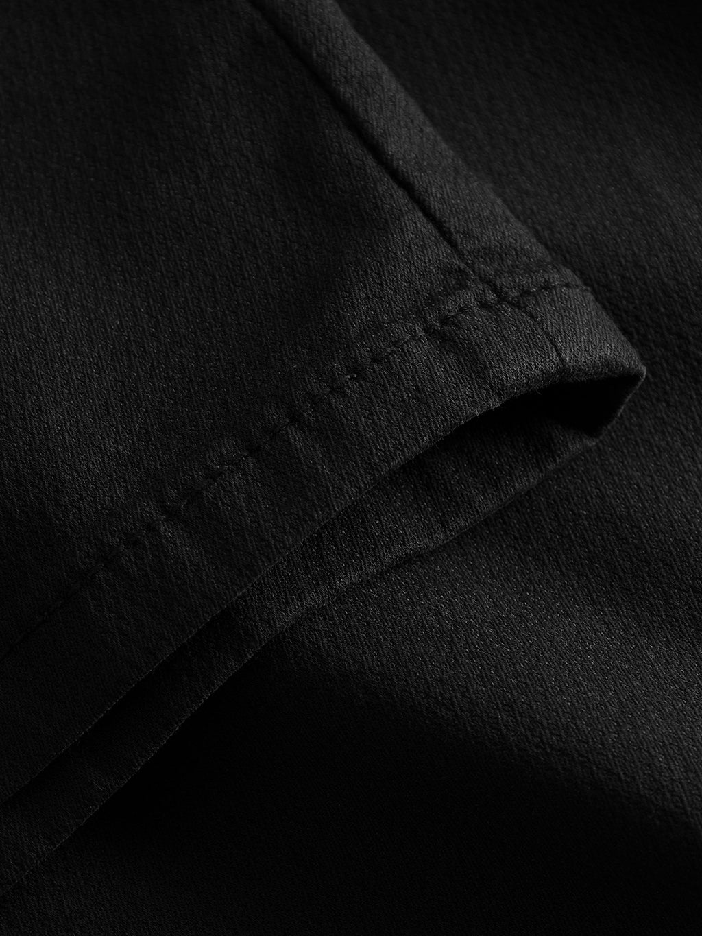 Close-up of the Paul K3280 Dale Chino - Black by GABBA, revealing detailed fabric texture and stitching. The lighting highlights its woven pattern, branded buttons, and smooth finish.