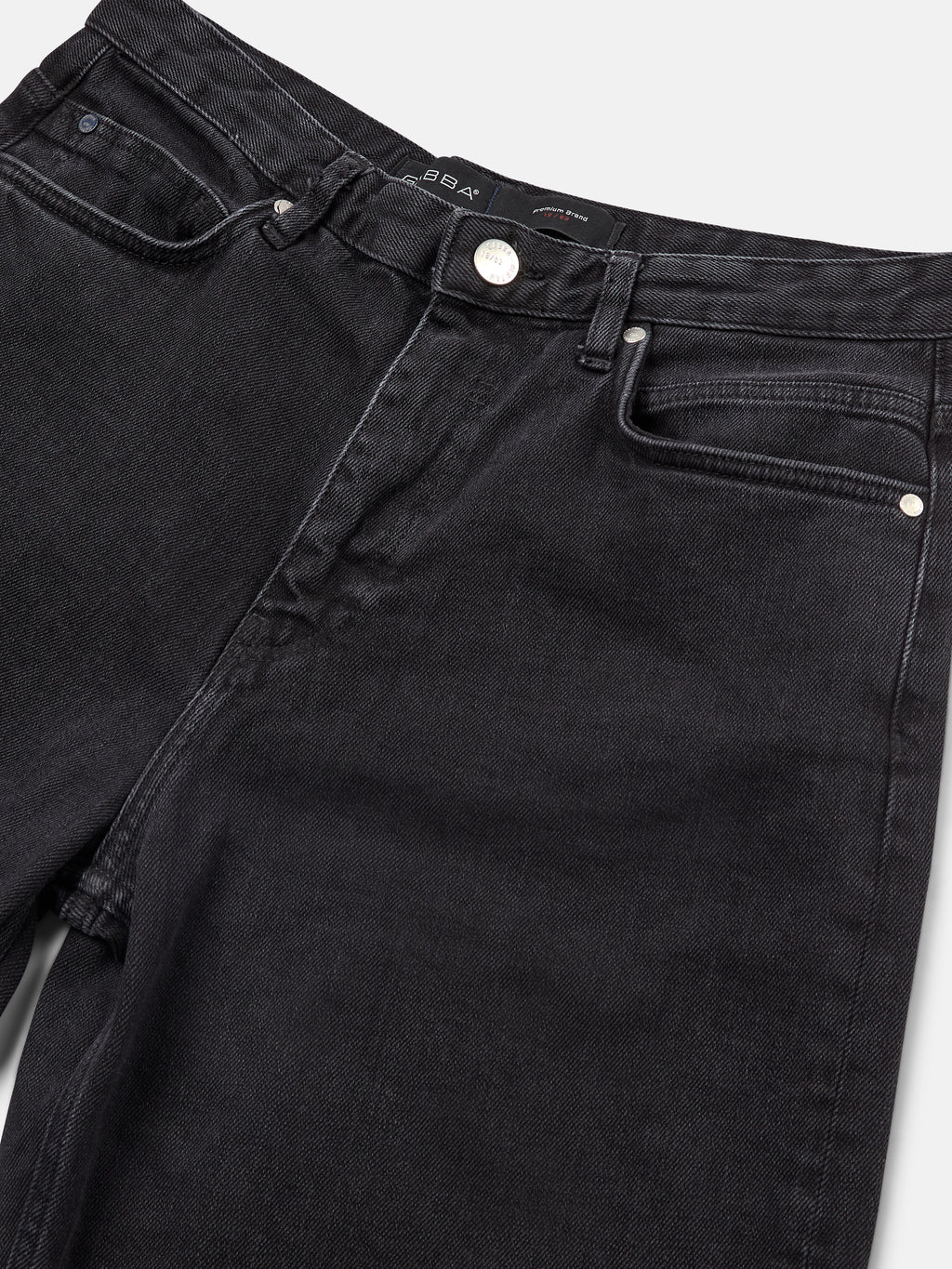 Close-up of Zem K1577 Jeans - Black Denim by GABBA, showcasing front pockets, button closure, visible brand label inside the waistband. Fabric texture and stitching details create a 90s Urban casual look against a white background.