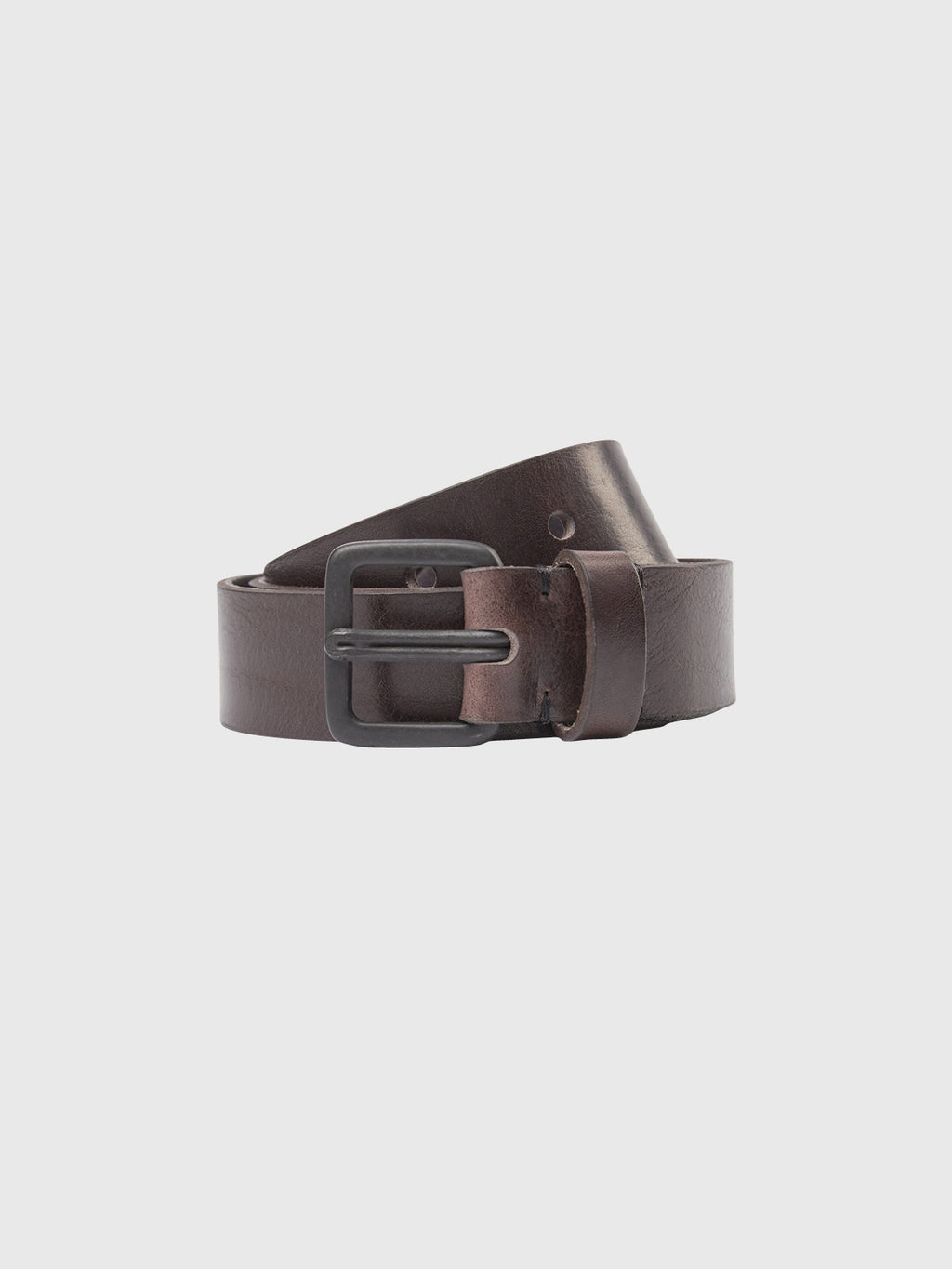 The Okay Belt - Brown by GABBA is displayed coiled with its metal buckle, contrasting against a light background in a masculine design.