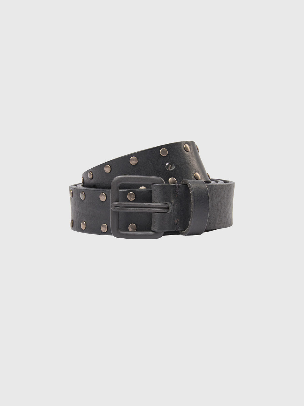 The Okay Stud Belt by GABBA, featuring a raw black leather finish with metal studs and a black metal buckle, is coiled on a light, plain background.