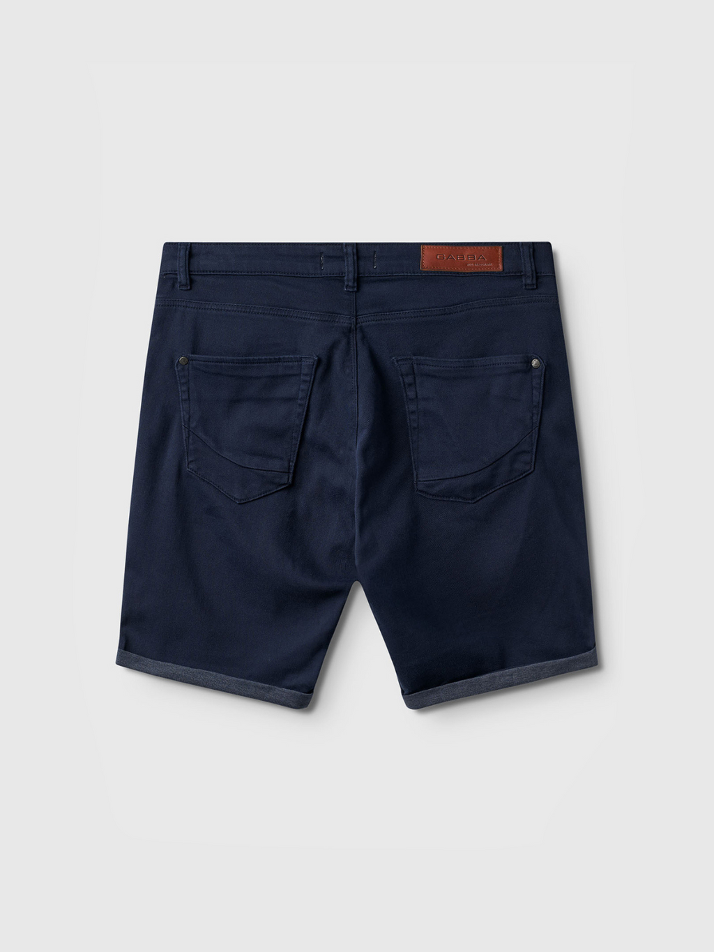 Back view of Gabba Jason K3995 SANZA Shorts in navy, knee-length with two back pockets, belt loops, a brown leather patch on the waistband, crafted from super-stretch fabric and shown on a plain light gray background.