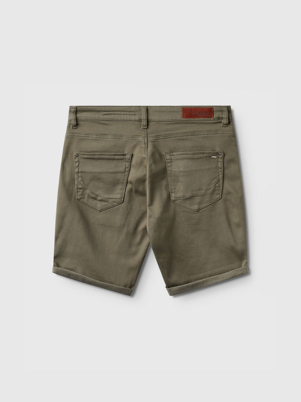 The Gabba Jason K3995 SANZA Shorts in Dusty Olive are knee-length denim shorts seen from the back, with two back pockets, rolled hems, belt loops, a brown leather patch on the waistband, and super stretch fabric for comfort.