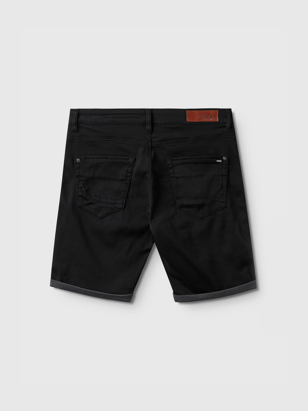 The Gabba Jason K3995 SANZA Shorts in black are knee-length denim shorts with two back pockets, rolled hems, and a brown leather patch on the waistband, shown from the back against a plain light background.