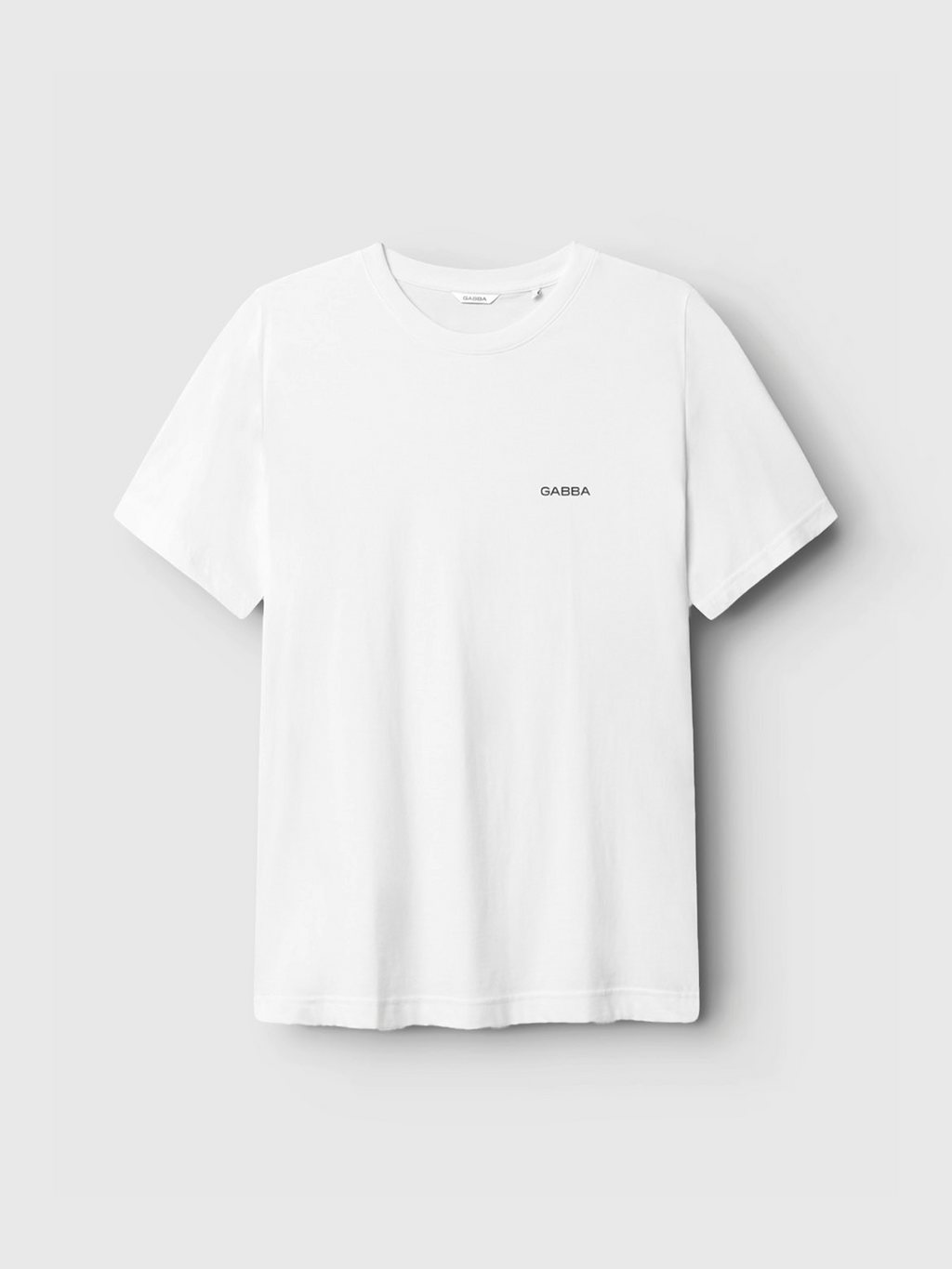 The Gabba Dune Logo SS GOTS - White is a classic fit t-shirt in plain white organic cotton, featuring “Gabba” in small black letters on the left chest, shown against a light gray background.