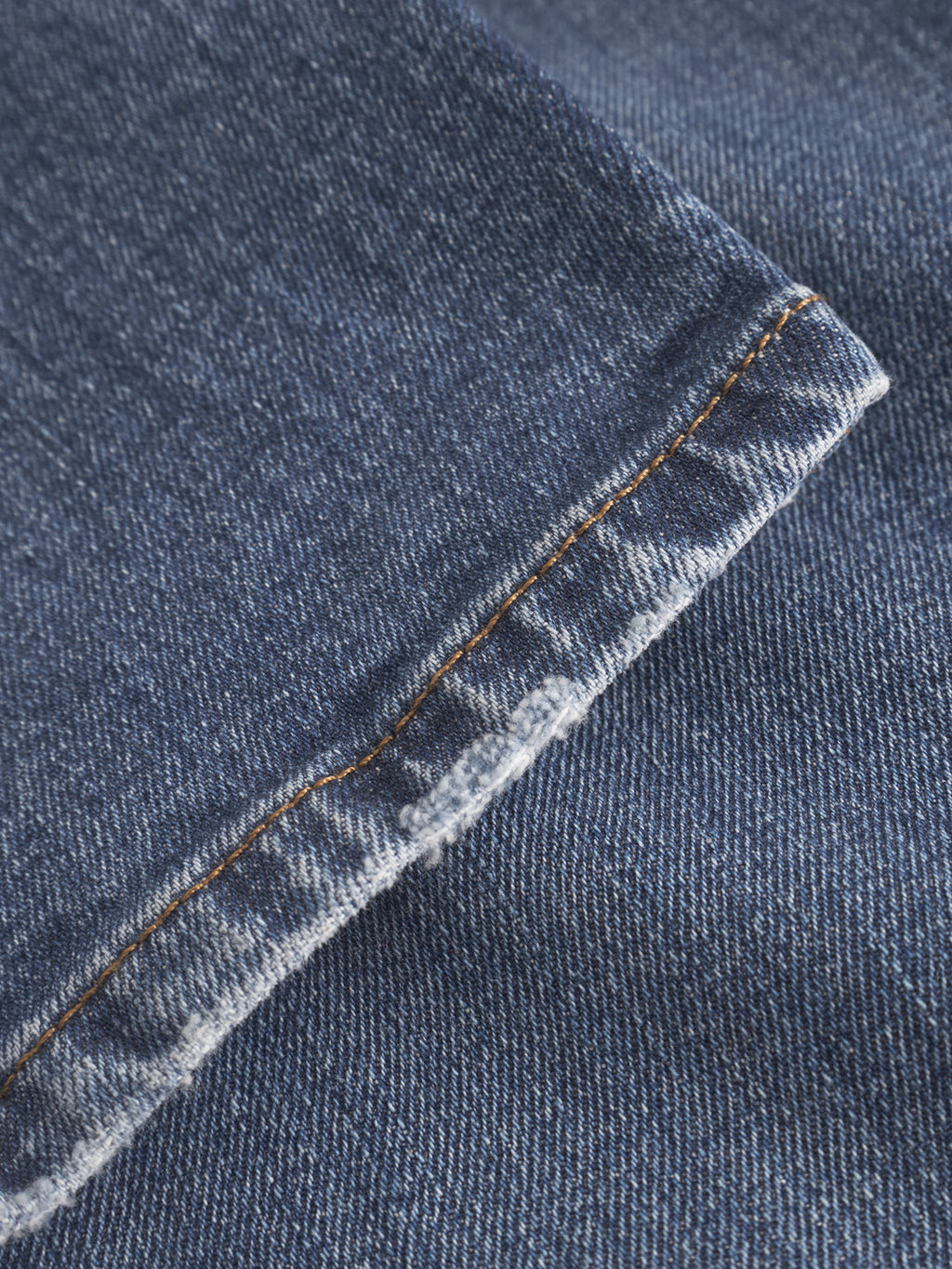 Close-up of Gabba GABmarc F1010 Dark Blue Denim, showing the classic fit fabric’s hem with orange-brown stitching and subtle fraying on the edge.