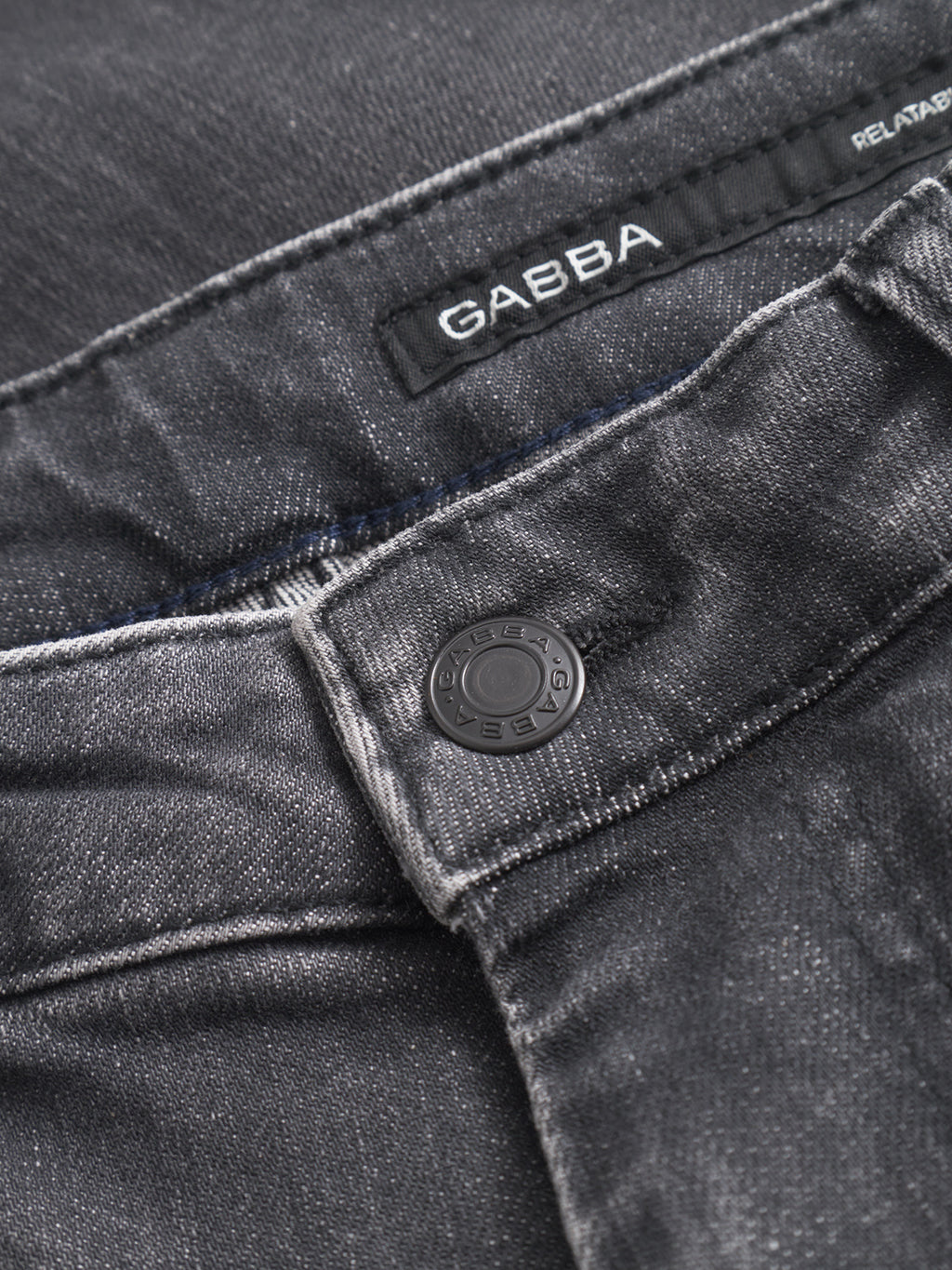 Close-up of the waistband and button on Gabba’s GABmarc F1011 black denim jeans. The inner label reads Gabba, and the button is embossed with the brand name.