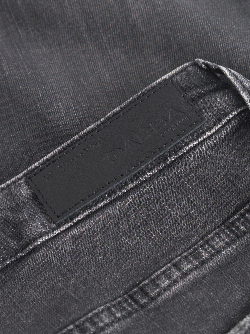 Close-up of GABmarc F1011 - Black Denim straight fit jeans by Gabba, featuring a dark gray wash and a black leather waistband patch embossed with the brand’s name.
