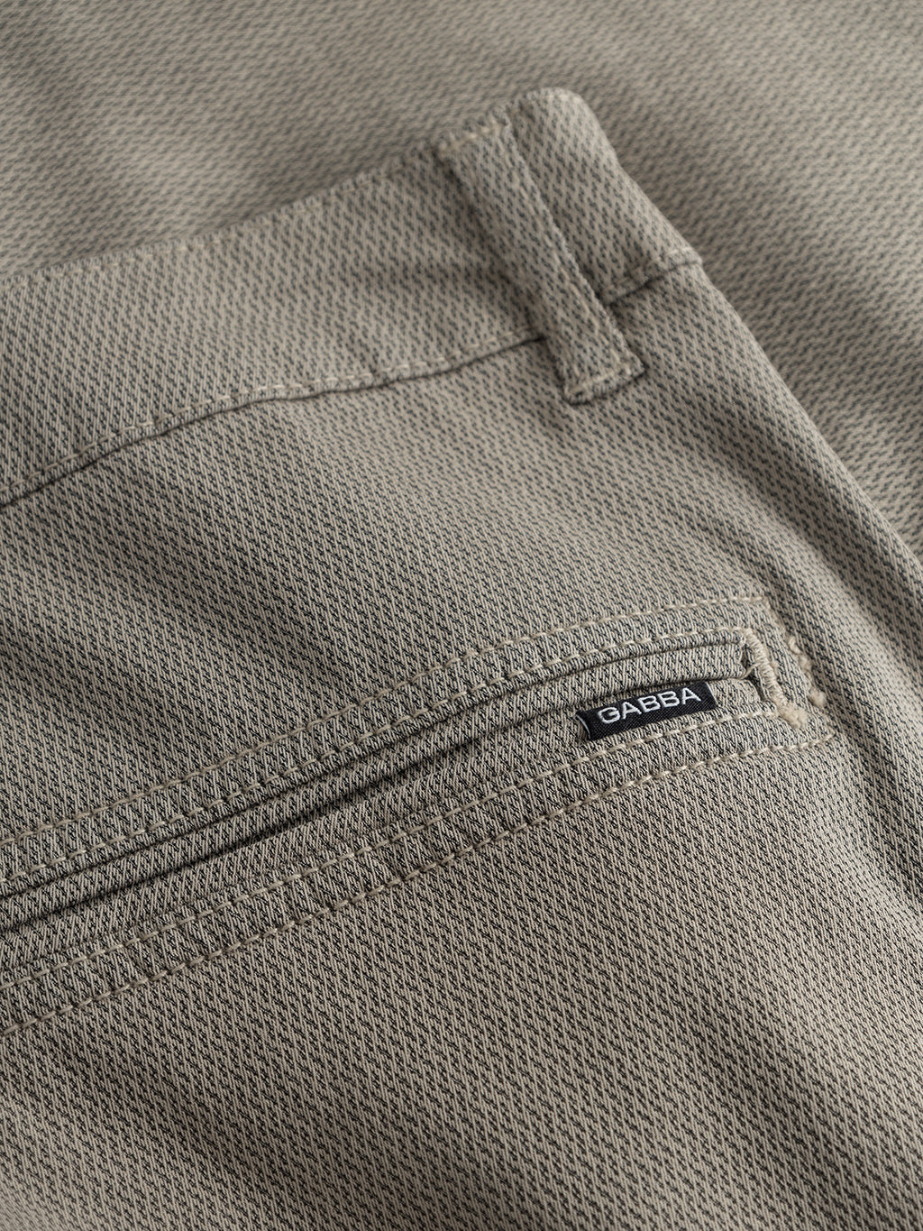 Close-up of the GABjet K3280 Dale Shorts in Humus by Gabba, showcasing the beige textured fabric and a back pocket with a small black Gabba label sewn onto the seam beneath the belt loop, emphasizing their timeless design and comfortable fit.