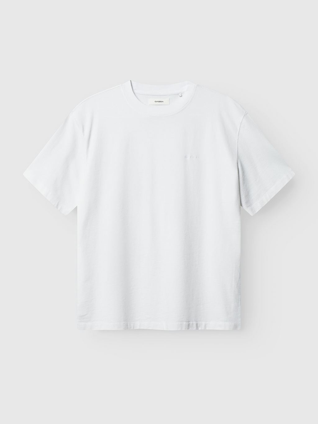The Gabba Nigel Wix Boxy Hour SS in white is a simple, logo-free casual tee with a classic crew neckline and modern fit, shown laid flat against a light gray background.