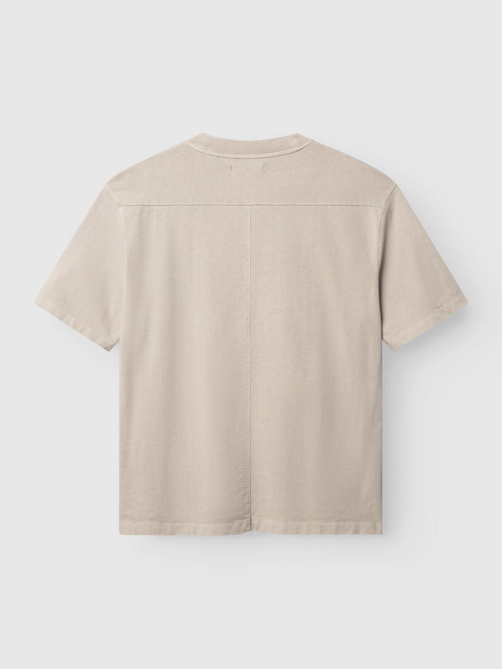 The Gabba Nigel Wix Boxy Hour SS - Sand Cashmere tee, shown from the back against a white background, is a beige, short-sleeved boxy-fit shirt with a straight seam on the upper back and another down the center.