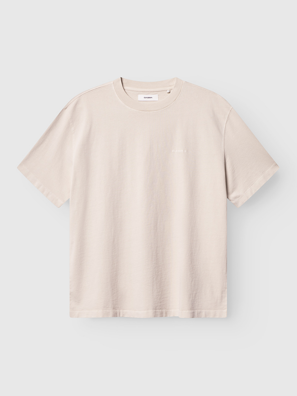 The Gabba Nigel Wix Boxy Hour SS in White Almond is a short-sleeved, structured cotton T-shirt with a boxy fit and crew neckline, showcasing a minimalist design without graphics or patterns, shown flat on a white background.