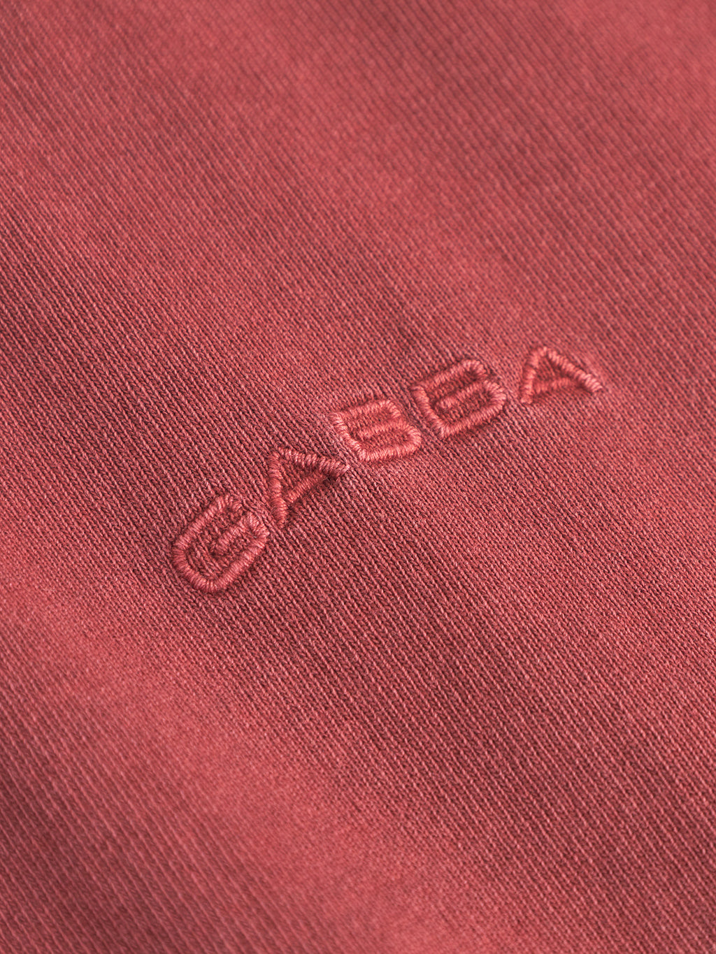 Close-up of Gabba’s Nigel Wix Boxy Hour SS in Red Russet, showing textured heavy-weight cotton with GABBA embroidered in matching thread.