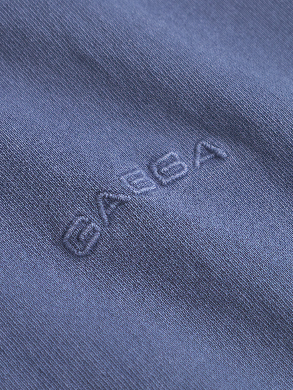 Close-up of vintage indigo heavyweight cotton fabric on the Gabba Nigel Wix Boxy Hour SS tee, featuring matching blue GABBA embroidery at the center. Detailed stitching and texture add a premium feel to this boxy shirt.