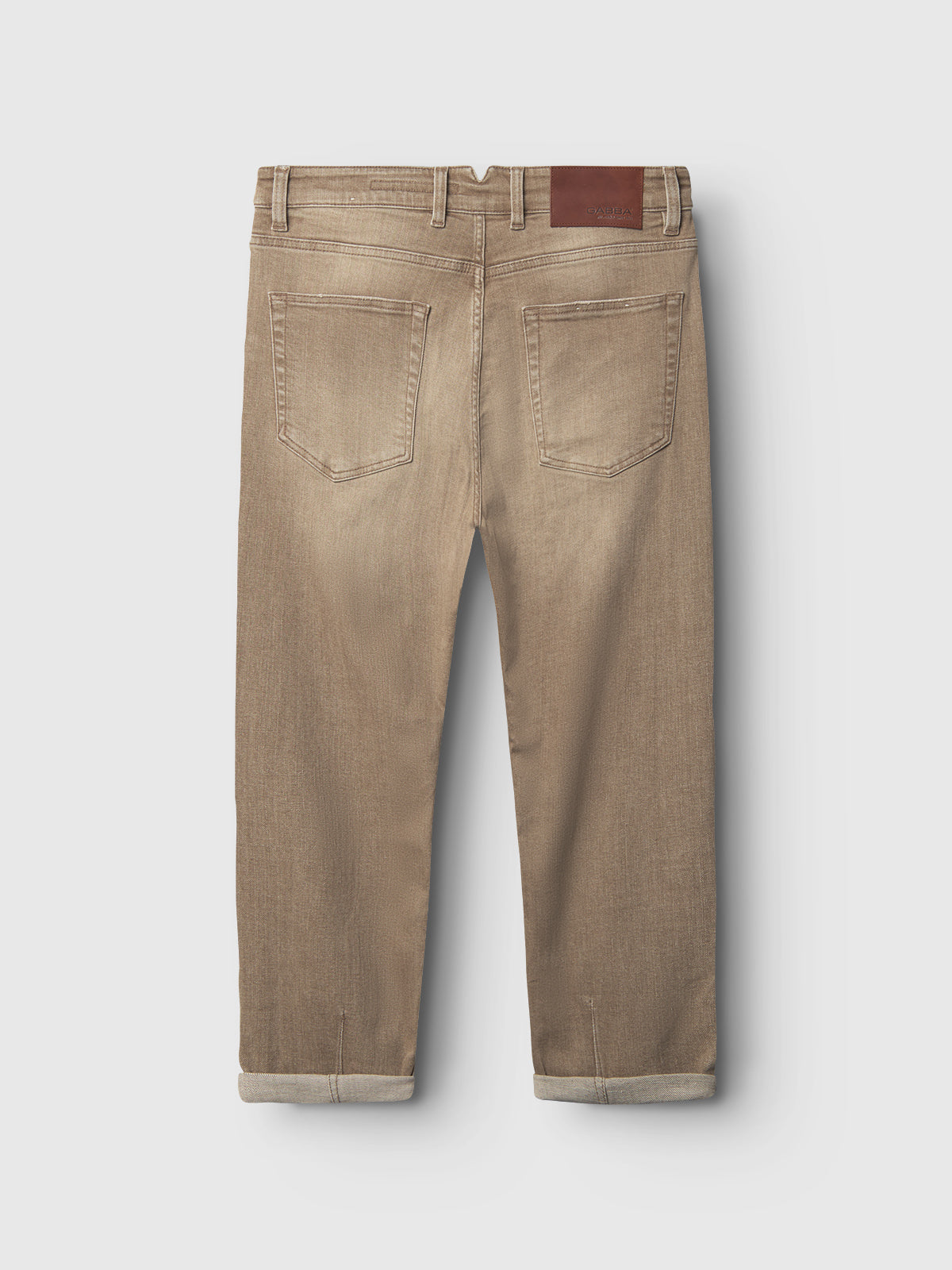 Gabba Alex Earth - Sand relaxed-fit jeans in khaki, shown from the back with two rear pockets, belt loops, rolled cuffs, and a brown leather patch on the waistband. Jeans are laid flat against a white background.