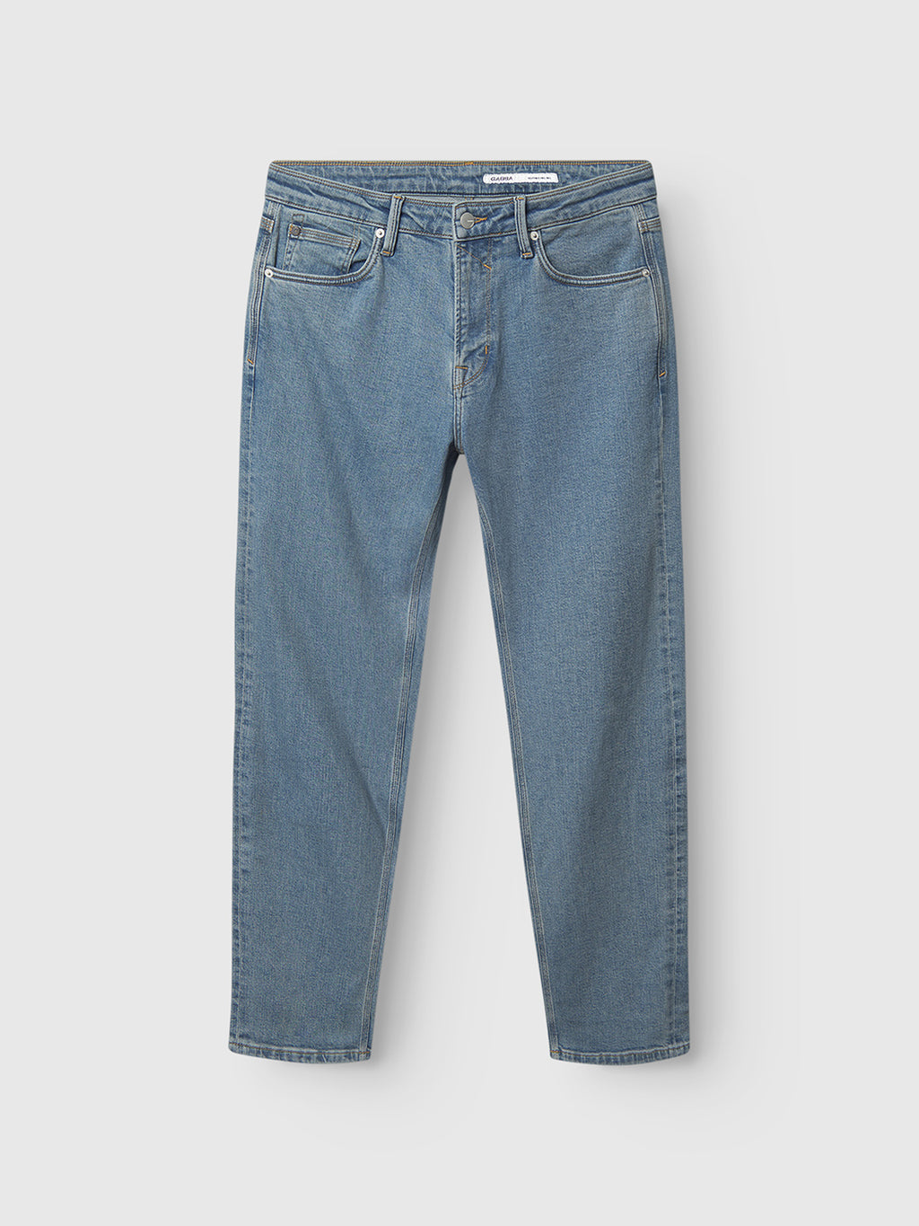 The Gabba Max Cros - Lt. Blue Denim features classic straight-leg jeans with five pockets and a button closure, showcasing timeless style on a light gray background.