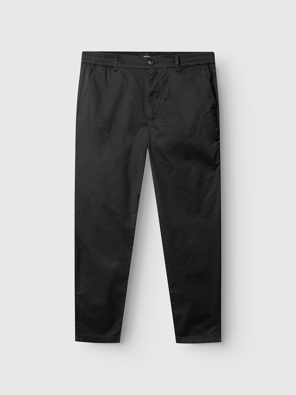 The Gabba Monza Unite - Black pants feature a relaxed straight fit, elastic waist, classic silhouette, side pockets, and button closure, shown laid flat on a light gray background.