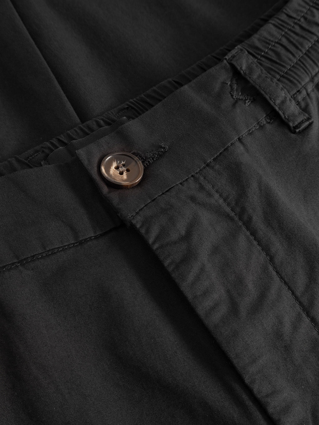 Close-up of the waistband and button of the Gabba Monza Unite - Black pant, showcasing stitching, buttonhole, and pocket flap details for a classic straight-leg silhouette.