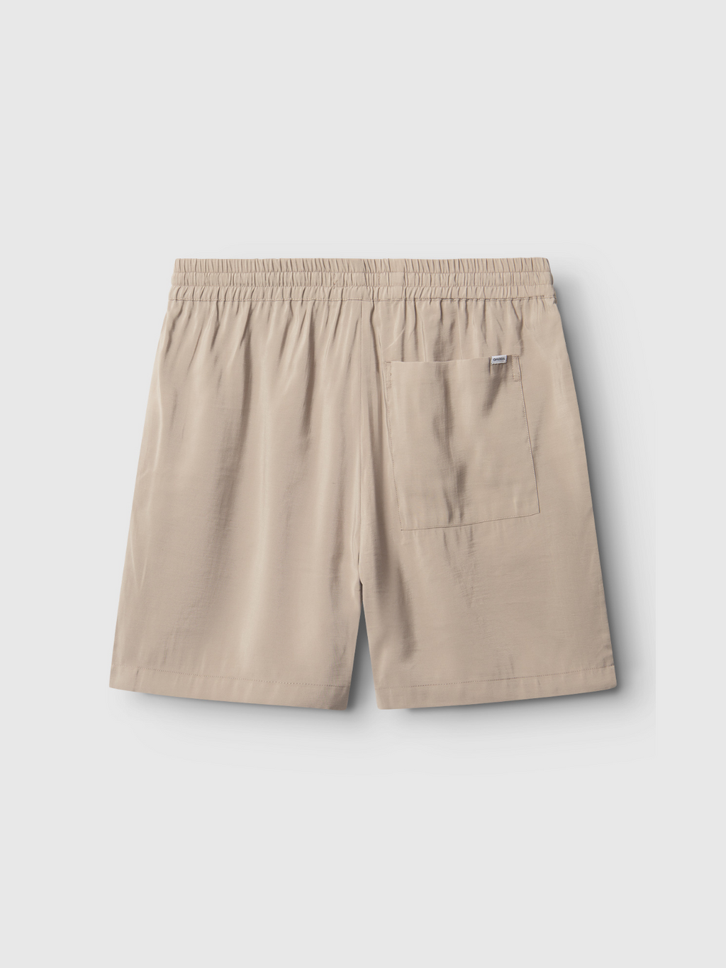 The Gabba Bo Yari - Sand Greige shorts feature an elastic waistband, a single large back patch pocket, and lightweight fabric for comfort, shown on a plain light gray background.
