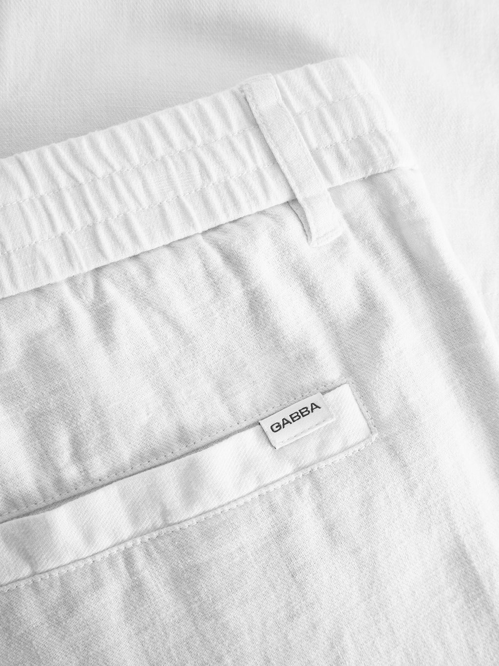Close-up of the Gabba Napoli 19 Side Lino pant in white, featuring an elastic waistband, belt loop, and a back pocket with subtle Gabba branding for a relaxed yet stylish look.