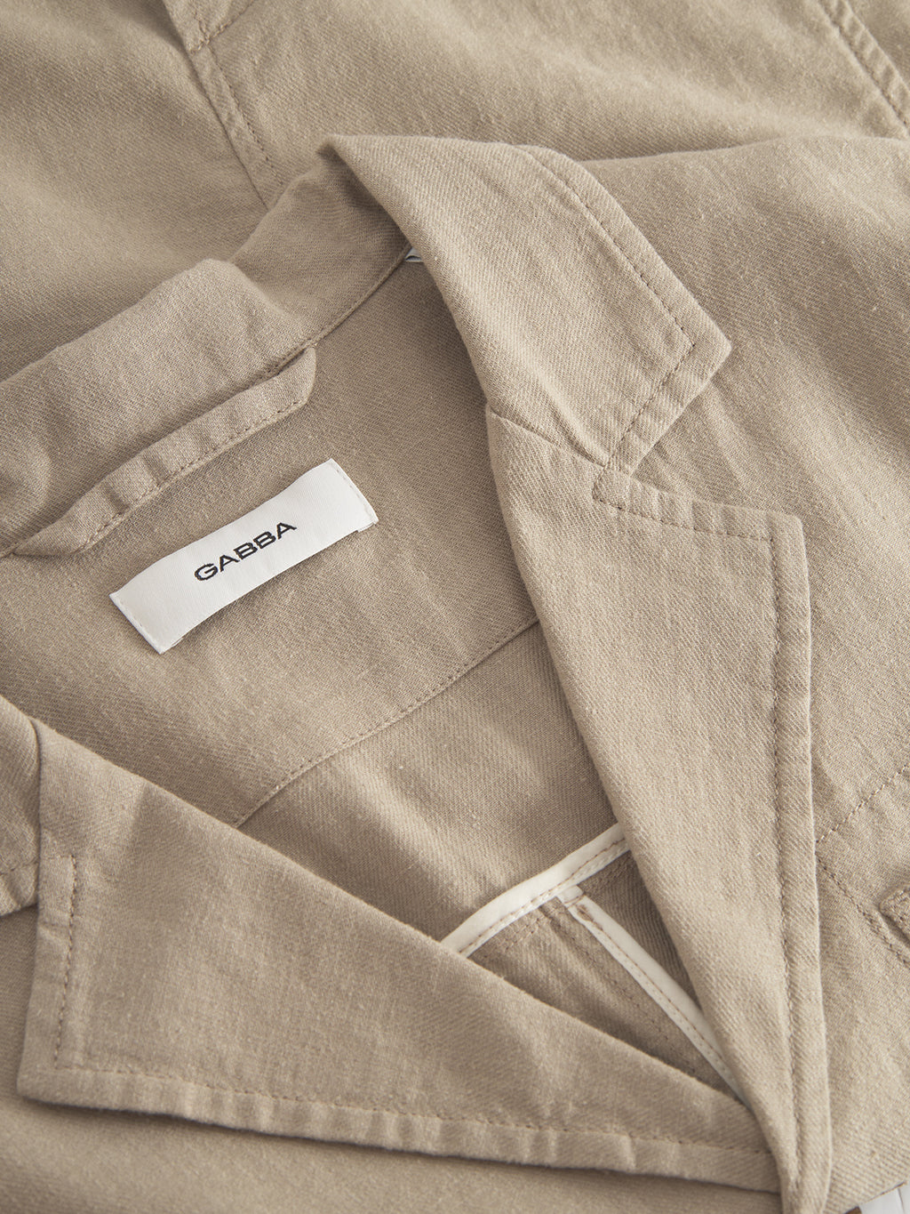 Close-up of beige fabric with a Gabba label