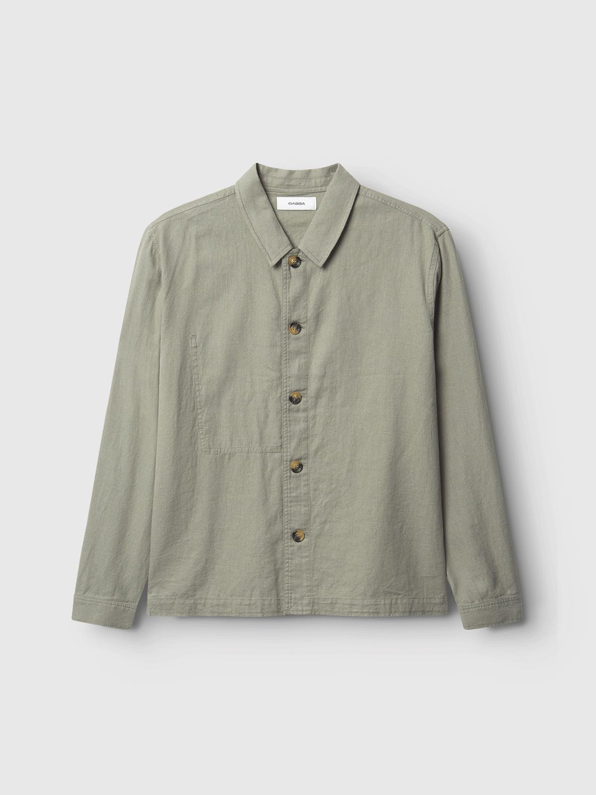 The Gabba Peter Lino in light green is a long-sleeved, collared overshirt with a chest pocket, made from breathable linen/cotton. Shown on a white background, it’s perfect for spring.