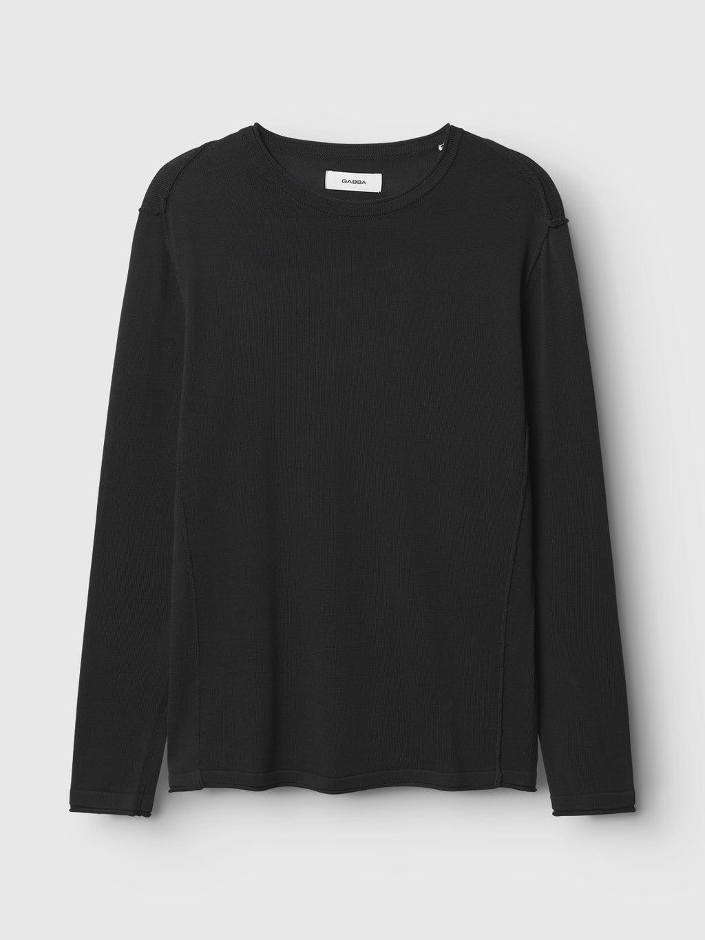 The Gabba Bela Fix LS - Meteorite is a black long-sleeve crew neck shirt made from 100% cotton, shown flat on a light grey background. Its premium knit offers comfort with a minimal design and no visible logos or patterns.
