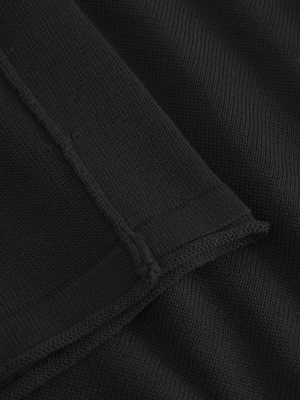 Close-up view of Bela Fix LS - Meteorite by Gabba, showing black textured 100% cotton fabric with visible stitching, hem details, and premium knit that highlights the weave and seams.