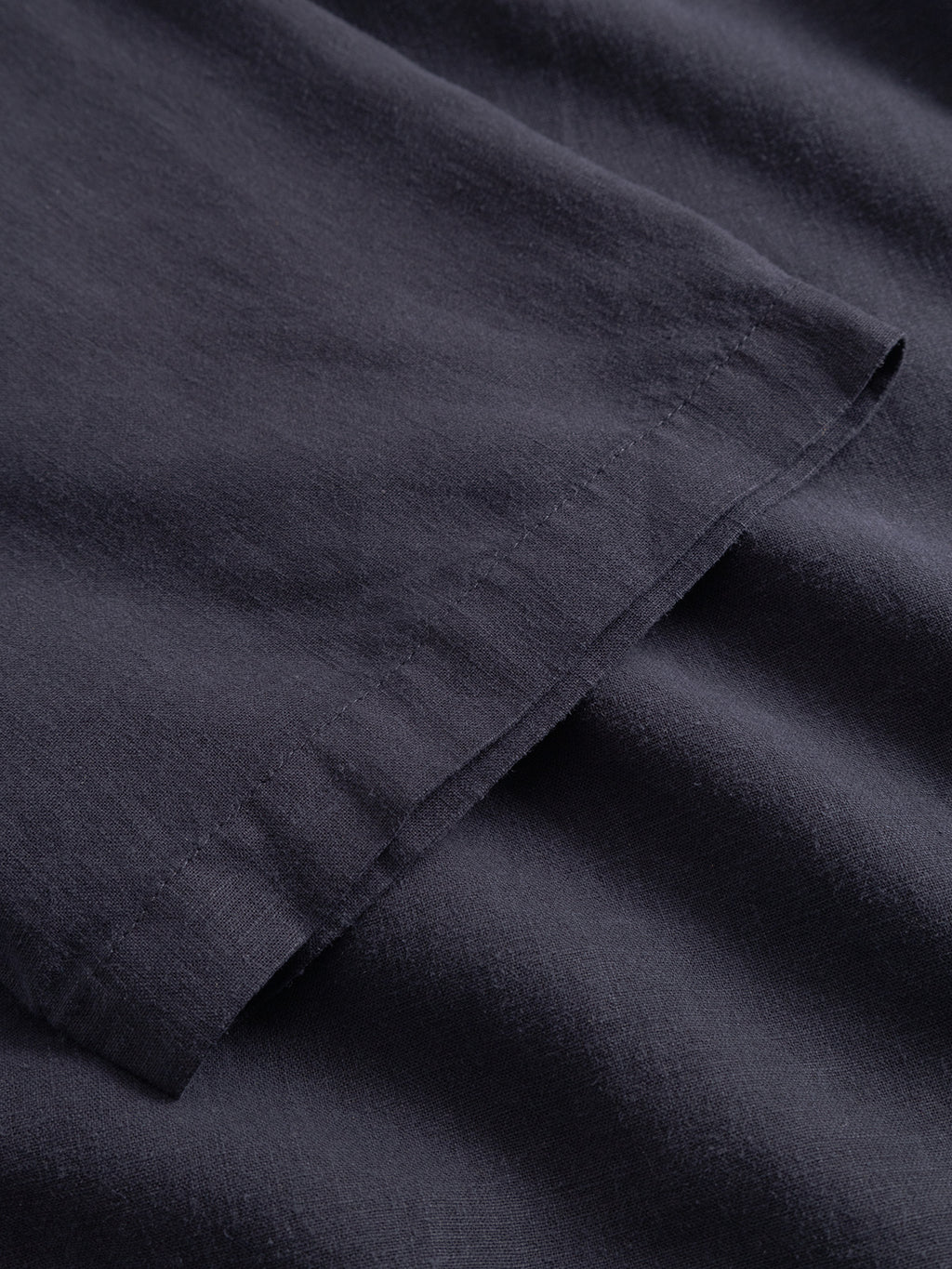 A close-up of Gabbas Sven Reg Lino SS in Night Sky highlights the hemmed edge and the smooth, slightly textured surface of its dark navy blue linen fabric.