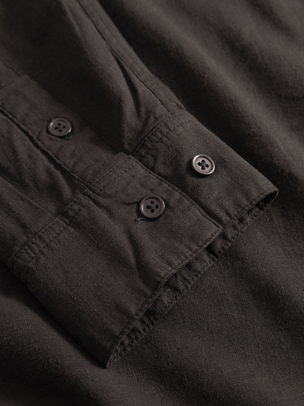 Close-up of the Sven Reg Lino LS - Meteorite by Gabba, featuring a linen sleeve with two black cuff buttons and detailed garment-dyed fabric texture and stitching.