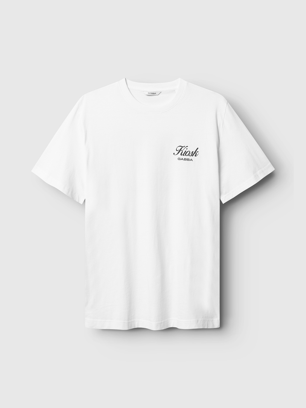 The Gabba Dune Kiosk C SS GOTS - White is a premium organic cotton short-sleeve t-shirt with Kush GARDA in small black script on the left chest, shown on a light gray background.