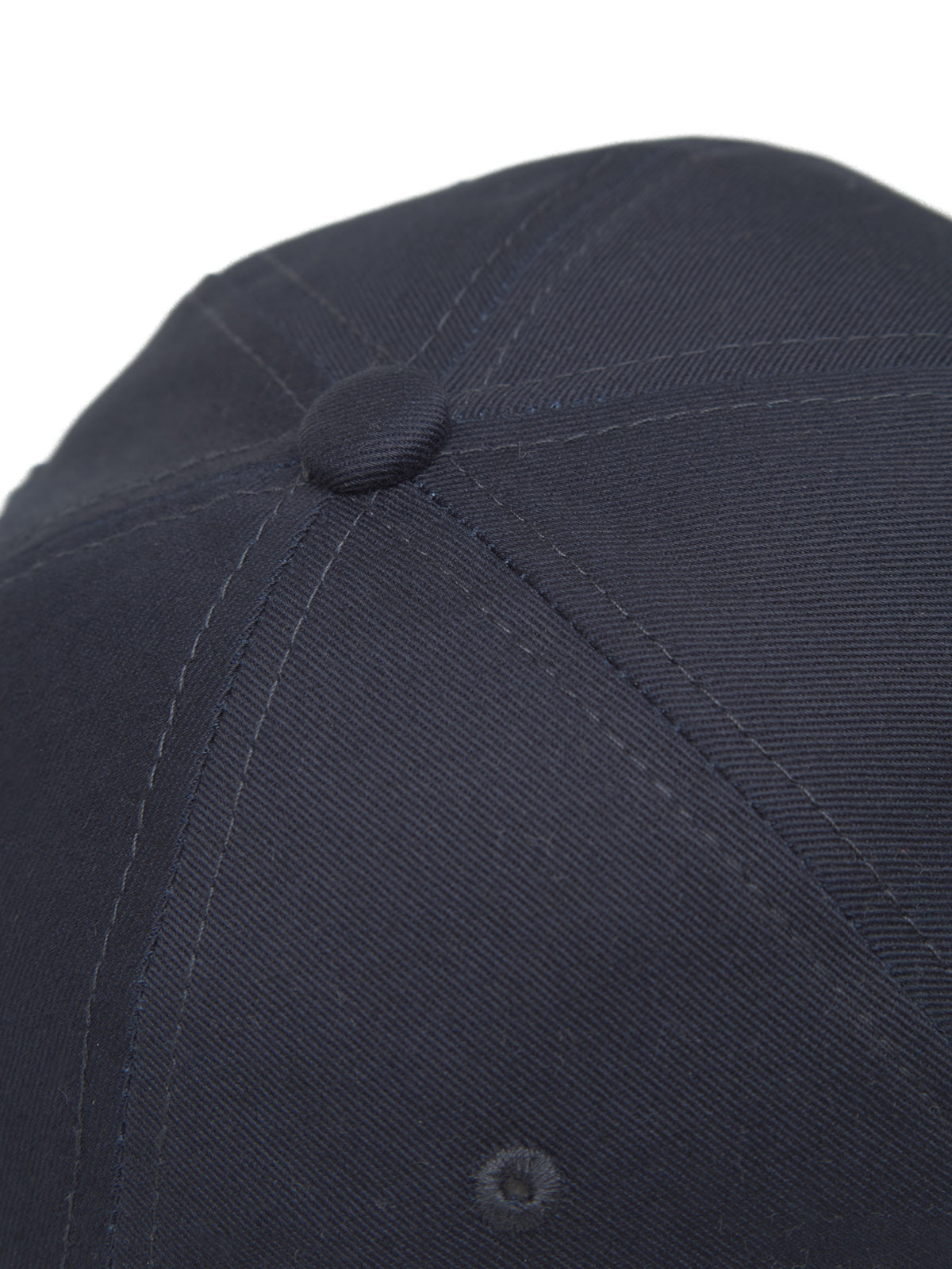 The Cashier Cap - Night Sky by Gabba features a close-up view of its dark twill fabric, showcasing detailed stitching and texture. The central button and panel seams accentuate the caps design.