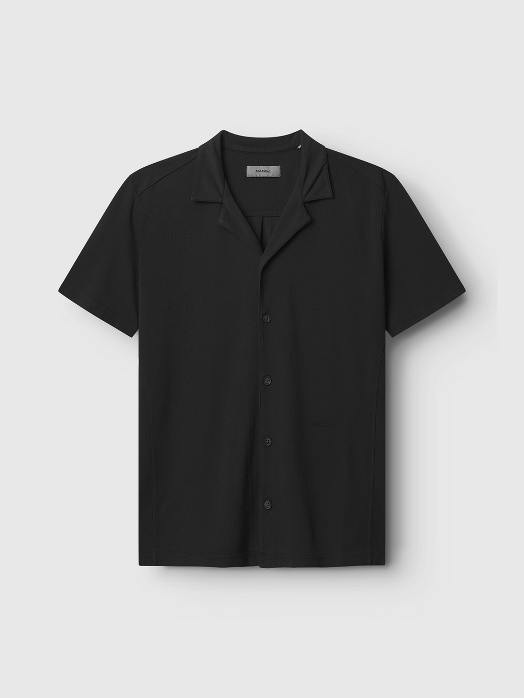 The Neo Pique Resort SS - Meteorite by Gabba is a black short-sleeve button-up shirt with a collar, shown against a light gray background. It combines ultimate comfort with a classic design, ideal for showcasing personal style.