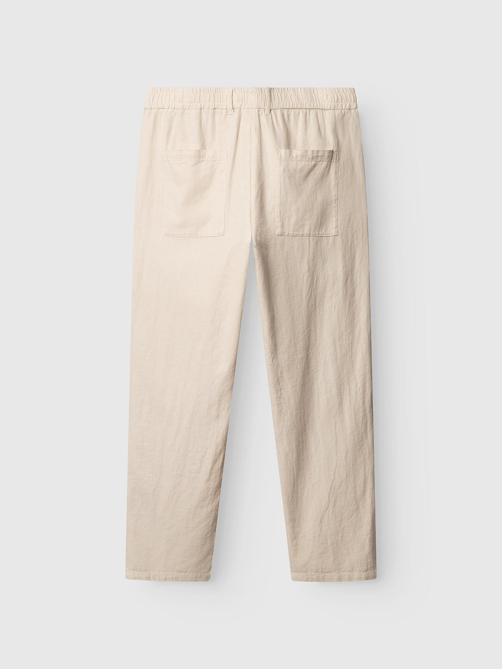 The Gabba GABzeta Lino - Birch pants are beige straight-leg linen trousers, shown from the back with an elastic waistband and two back patch pockets, displayed against a plain light grey background.