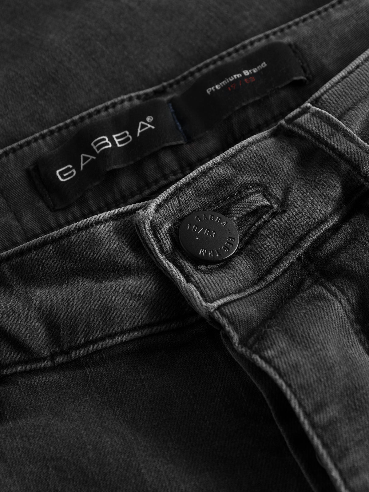 Close-up of GABrey Thor Jeans - Denim wash showing the waistband, a black metal button engraved with GABBA 1983 WEAR, and a label with the GABBA brand name and 