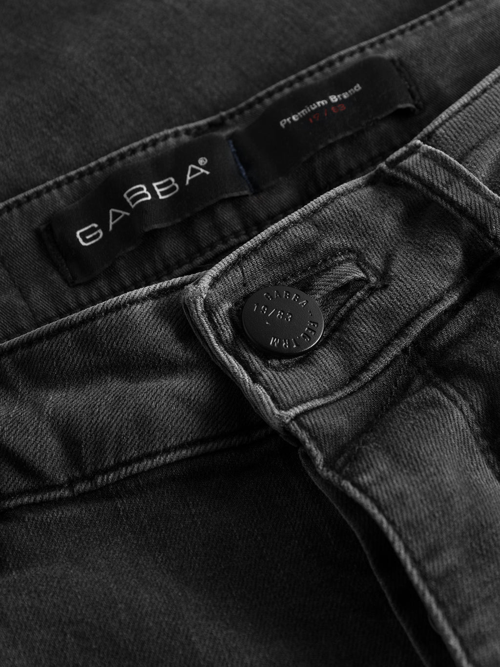 Close-up of GABrey Thor Jeans - Denim wash showing the waistband, a black metal button engraved with GABBA 1983 WEAR, and a label with the GABBA brand name and 