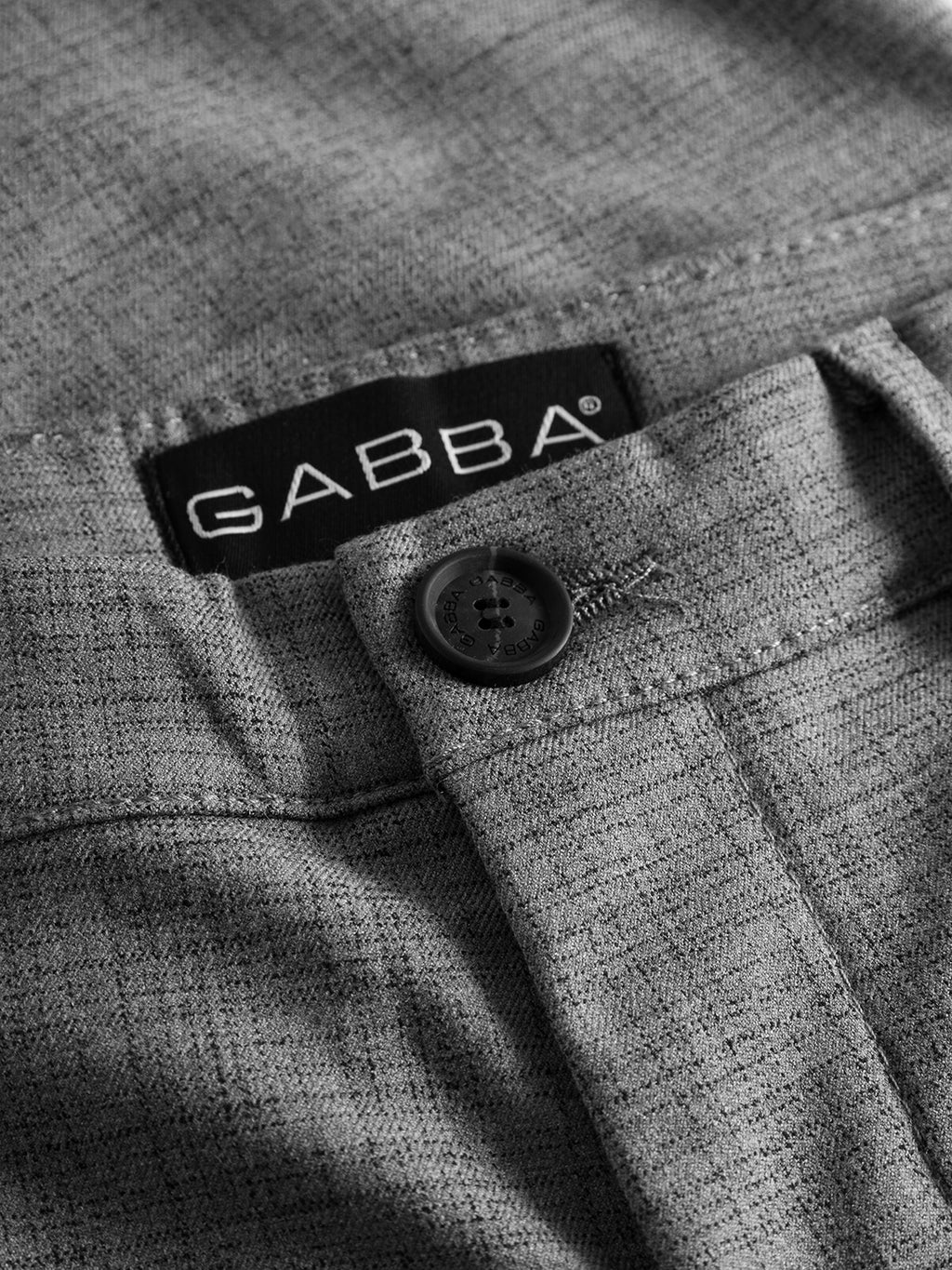 Close-up of GABBA Pisa Cross Lt Grey pants in light gray high-stretch cotton-blend, highlighting the waistband, black button, detailed stitching, and signature black GABBA label—ideal for refined metro style.