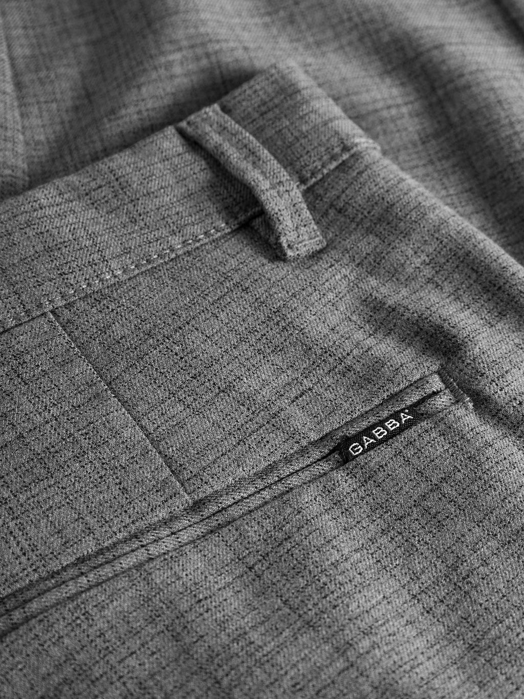 Close-up of GABBA Pisa Cross Lt Grey pants in metro style, crafted from high-stretch cotton-blend fabric with a textured finish, belt loops, pocket seam, and a small black GABBA tag.